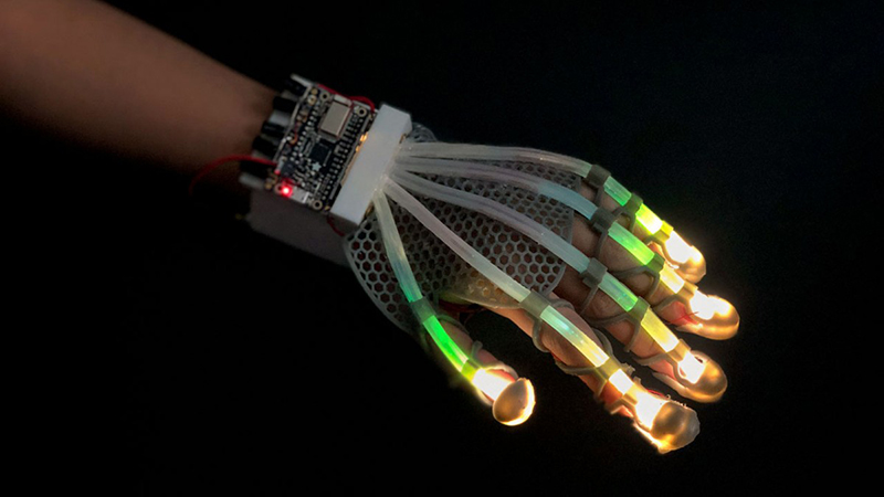 The stretchable skin, integrated here into a glove, contains long sensors that detect a range of deformations (Credit: Cornell University)