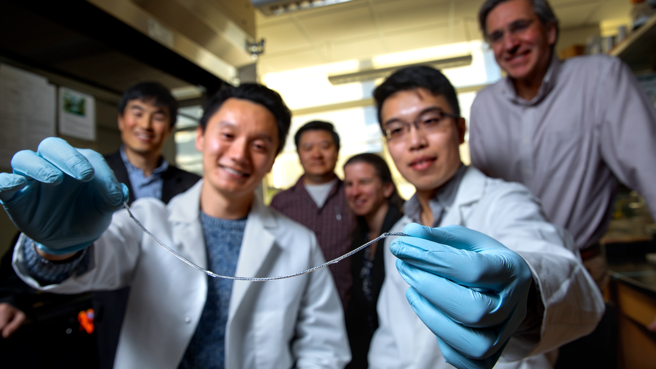 Researchers from Cornell University hold up a sample of the thread (Credit: Cornell University)