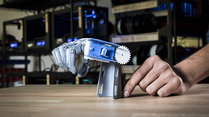 The University of Washington team 3D printed an e-NABLE arm with a prototype of their bidirectional sensor (blue and white) that monitors the hand opening and closing by determining the angle of the wrist (Credit: Mark Stone/ University of Washington)