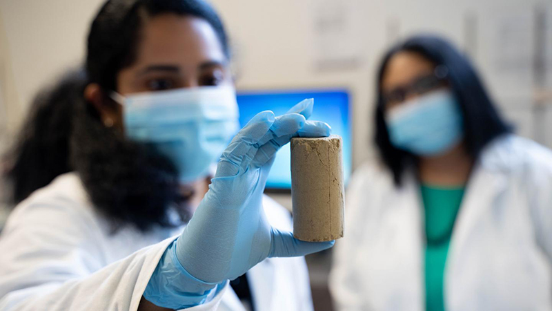 Dr Chinchu Cherian examines a road-building material created partly with recycled wood ash (Credit: UBCO)