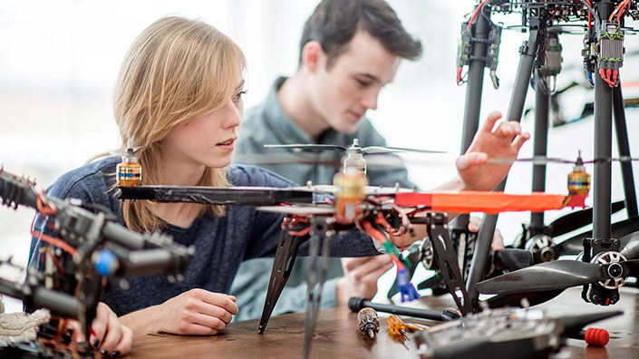 A group of students working on building a machine with drone parts (Credit: iStock)