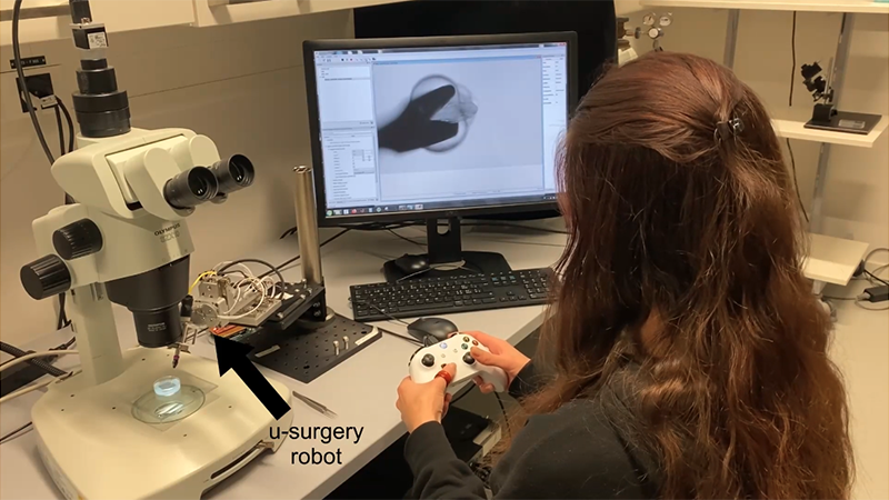 研究人员控制着机器人显微外科医生(来源:EPFL)