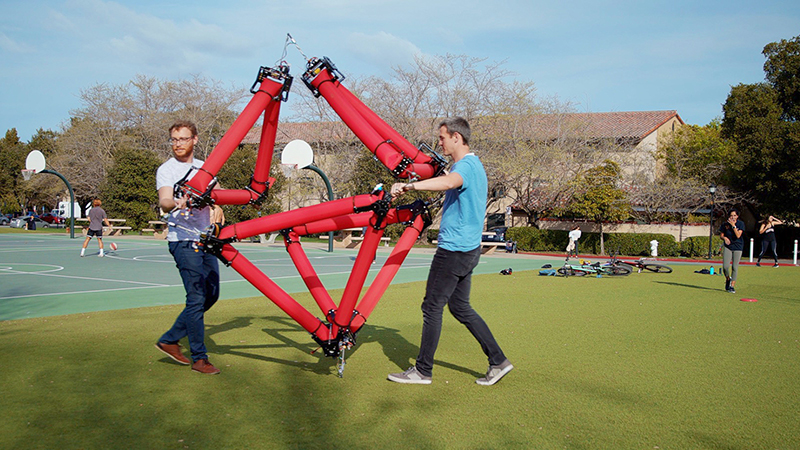 Zachary Hammond (left) and Nathan Usevitch pick up and move the isoperimetric robot, demonstrating its lightweight, damage resistant and safe characteristics (Credit: Farrin Abbott)