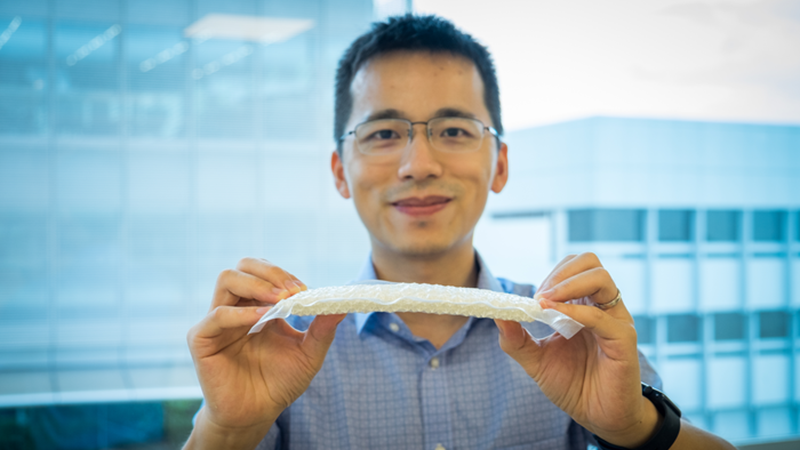 NTU Singapore assistant professor Wang Yifan bends the 3D-printed nylon 'chain mail' (Credit: NTU Singapore)
