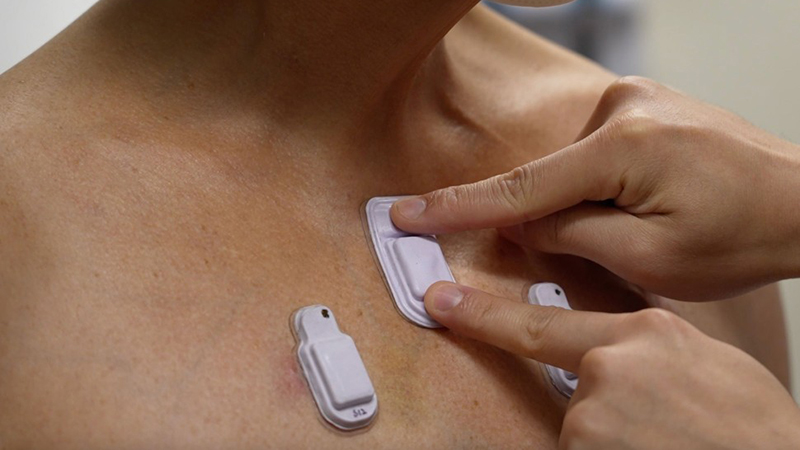A healthcare worker places the wearable devices across a patient's chest to capture sounds throughout the lungs (Credit: Northwestern University)