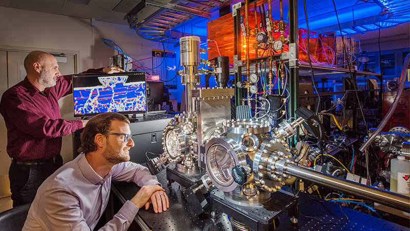 Sandia National Laboratories researchers show a computer simulation used to predict the unprecedented wear resistance of their platinum-gold alloy, and an environmental tribometer used to demonstrate it. (Photo by Randy Montoya)