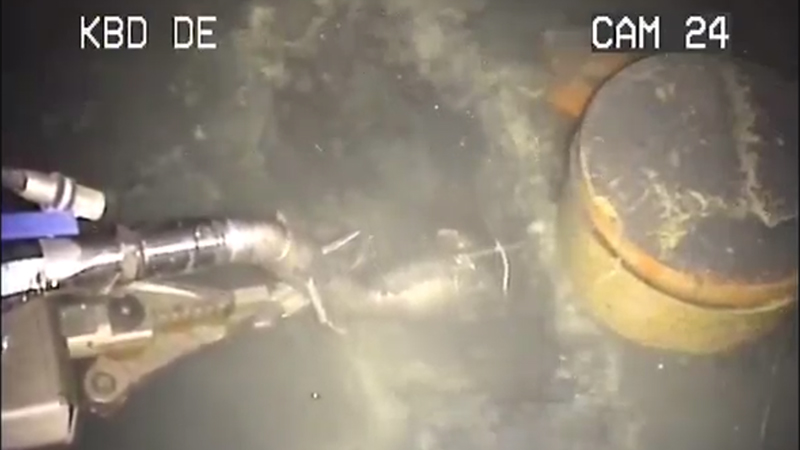 The Brokk manipulator robot (left) hoovers underwater radioactive sludge at Sellafield's D-Bay (Screenshot credit: Sellafield Sites/ YouTube)